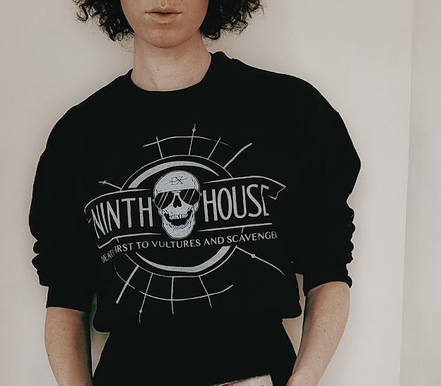 Gideon the ninth themed ninth house sweatshirt in black with skull and the phrase "death first to vultures and scavengers" and three of the books from the series