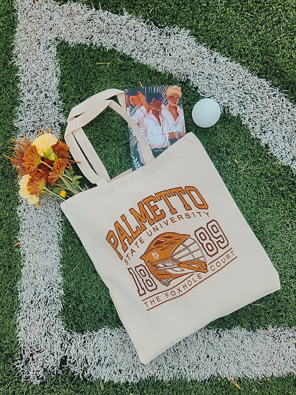 Photo of a foxhole court palmetto state university tote bag on a grass field.