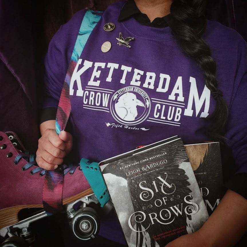 Ketterdam crow club university with crow logo sweatshirt worn by model in a college student style 