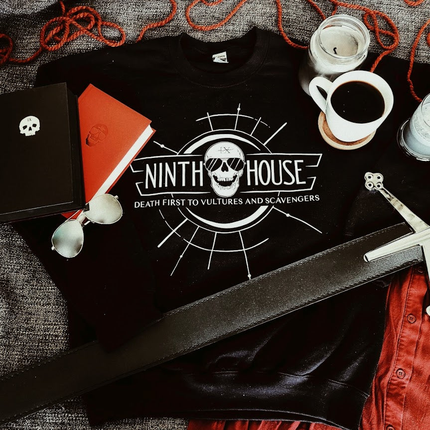 Gideon the ninth themed ninth house sweatshirt in black flatlay with skull and the phrase "death first to vultures and scavengers" 