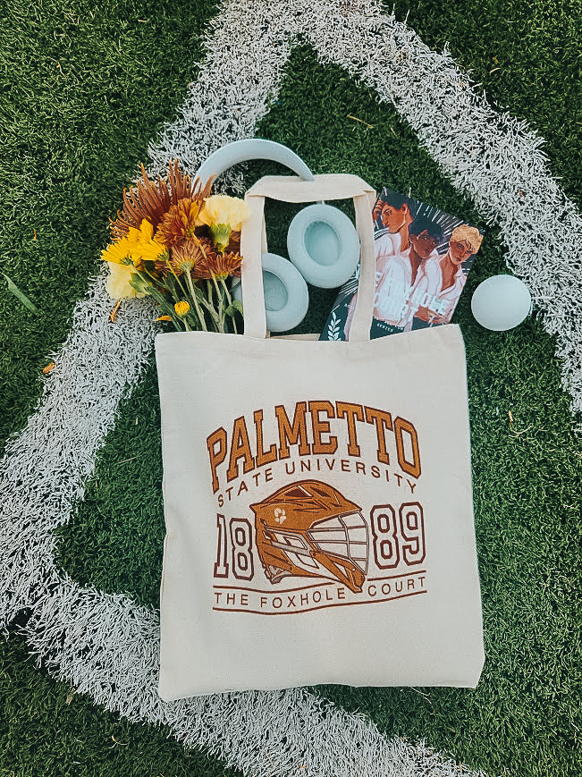 Photo of a foxhole court palmetto state university tote bag on a grass field.