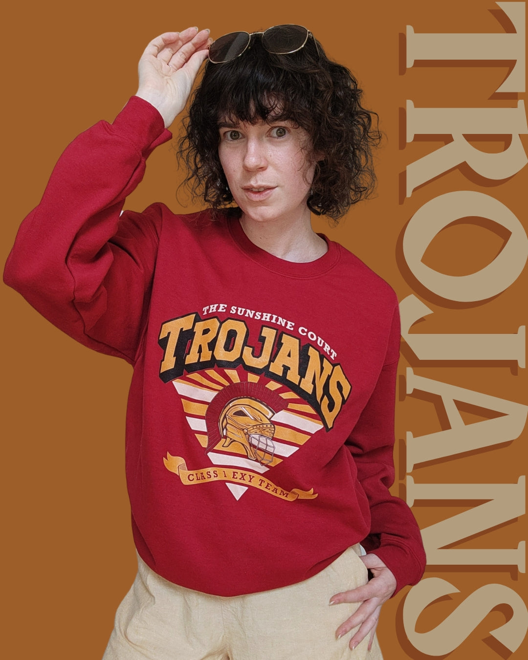 Trojan Sunshine Court Sweatshirt in Red with the word trojans behind the model